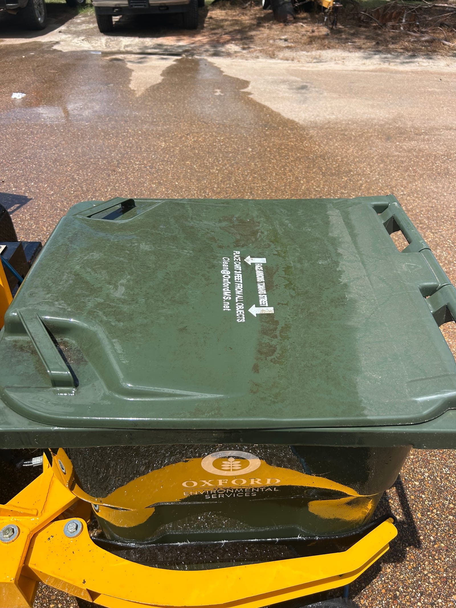 Freshly cleaned green trash bin on the Can Man rig