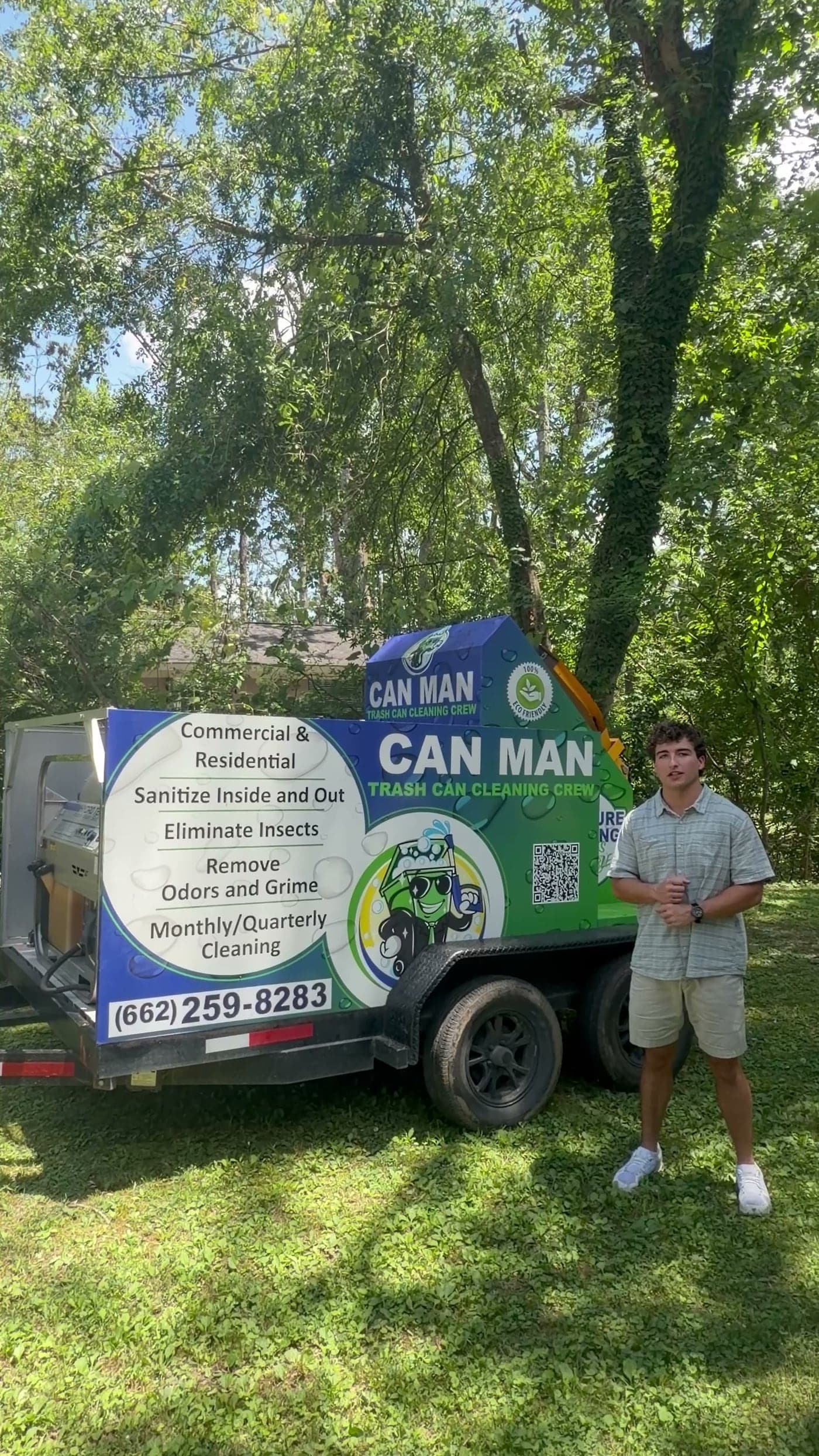 The owner of Can Man standing beside his branded trash can cleaning and pressure washing rig